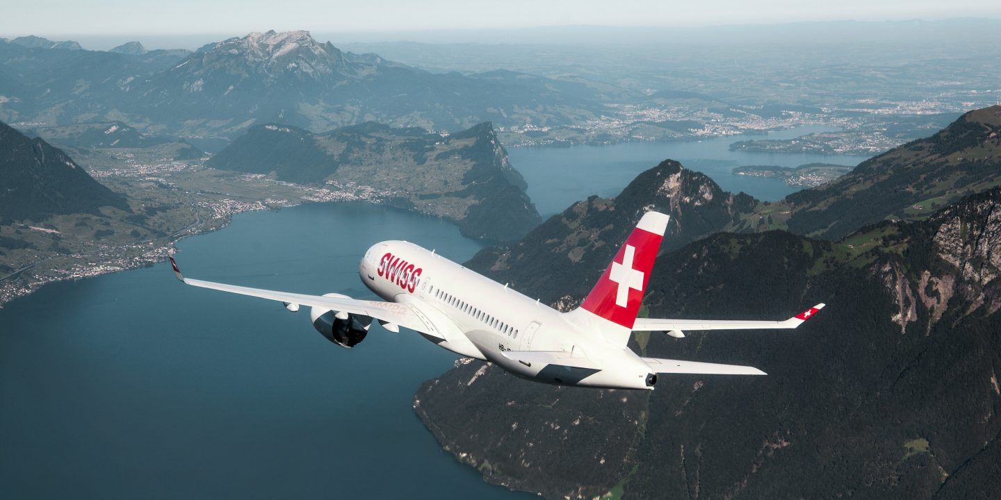 Ein Flugzeug der SWISS Airlines über eine Bergseekulisse